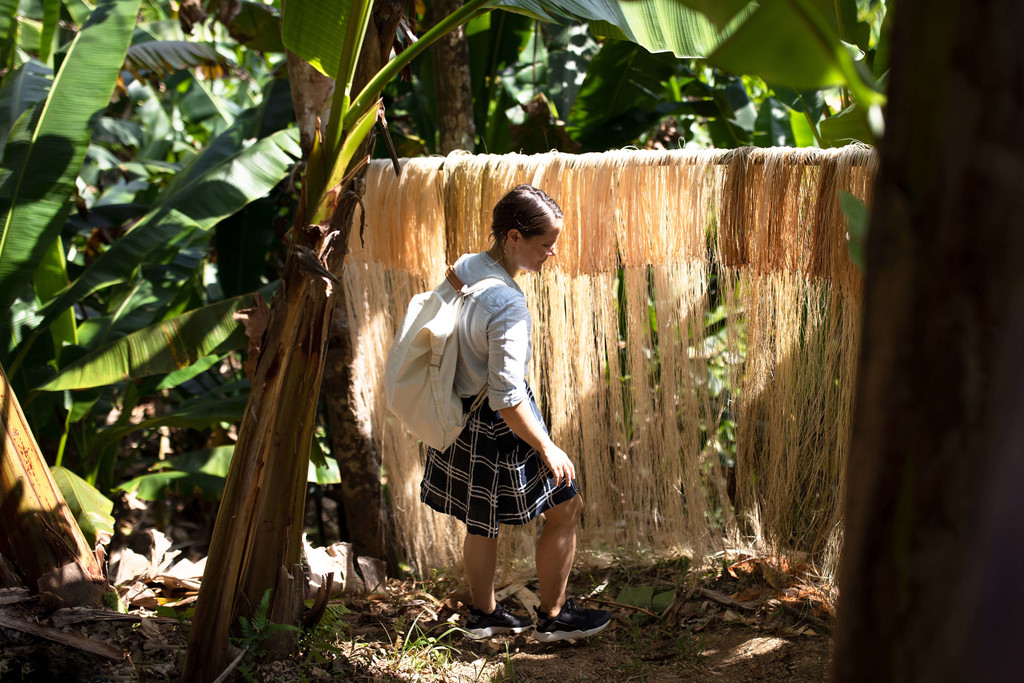 An image from the Qwstion campaign showing a model wearing the Bananatex backpack in front of fibres hung to dry - © Photograph: Lauschicht, Swiss Design Awards Blog